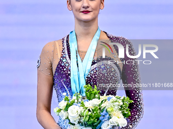 Gold medalist Alina Harnasko of Belarus celebrates on the podium after the Individual Clubs Final of the International Rhythmic Gymnastics T...