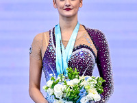 Gold medalist Alina Harnasko of Belarus celebrates on the podium after the Individual Clubs Final of the International Rhythmic Gymnastics T...