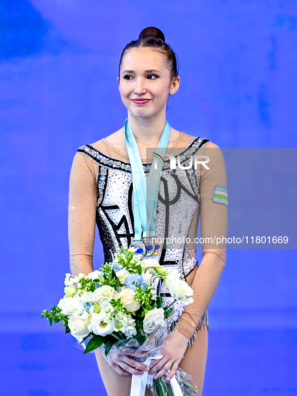 Silver medalist Takhmina Ikromova of Uzbekistan celebrates on the podium after the Individual Clubs Final of the International Rhythmic Gymn...