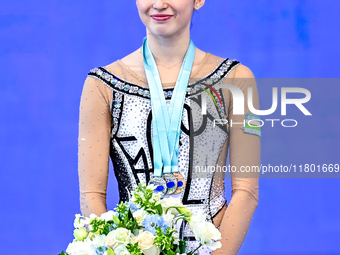 Silver medalist Takhmina Ikromova of Uzbekistan celebrates on the podium after the Individual Clubs Final of the International Rhythmic Gymn...