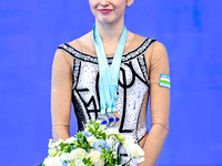 Silver medalist Takhmina Ikromova of Uzbekistan celebrates on the podium after the Individual Clubs Final of the International Rhythmic Gymn...