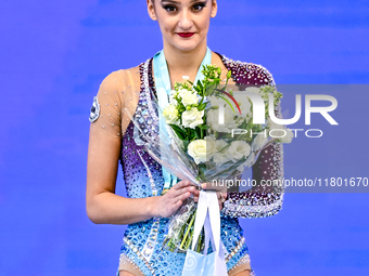 Gold medalist Alina Harnasko of Belarus celebrates on the podium after the Individual Clubs Final of the International Rhythmic Gymnastics T...