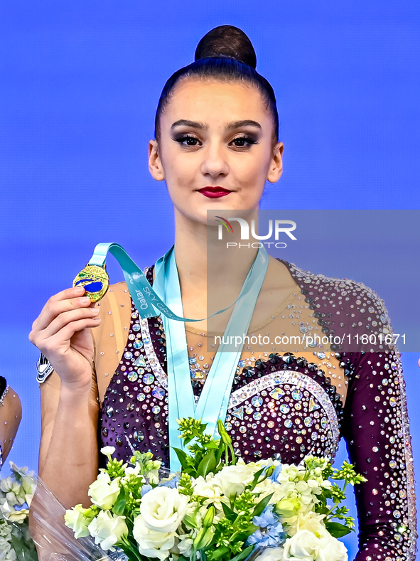 Gold medalist Alina Harnasko of Belarus celebrates on the podium after the Individual Clubs Final of the International Rhythmic Gymnastics T...