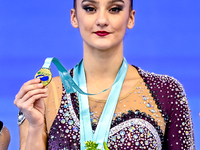 Gold medalist Alina Harnasko of Belarus celebrates on the podium after the Individual Clubs Final of the International Rhythmic Gymnastics T...