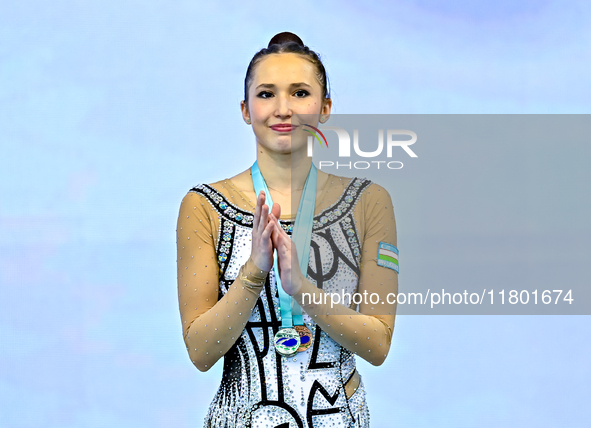 Silver medalist Takhmina Ikromova of Uzbekistan celebrates on the podium after the Individual Clubs Final of the International Rhythmic Gymn...