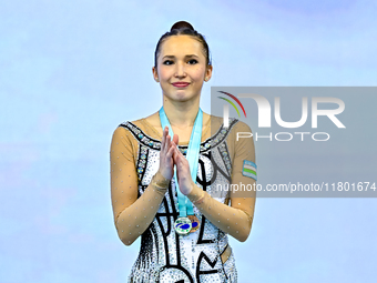 Silver medalist Takhmina Ikromova of Uzbekistan celebrates on the podium after the Individual Clubs Final of the International Rhythmic Gymn...