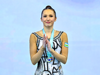 Silver medalist Takhmina Ikromova of Uzbekistan celebrates on the podium after the Individual Clubs Final of the International Rhythmic Gymn...