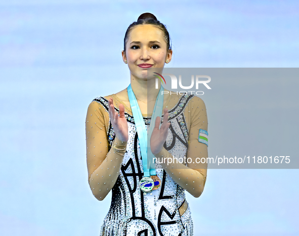 Silver medalist Takhmina Ikromova of Uzbekistan celebrates on the podium after the Individual Clubs Final of the International Rhythmic Gymn...