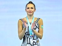 Silver medalist Takhmina Ikromova of Uzbekistan celebrates on the podium after the Individual Clubs Final of the International Rhythmic Gymn...