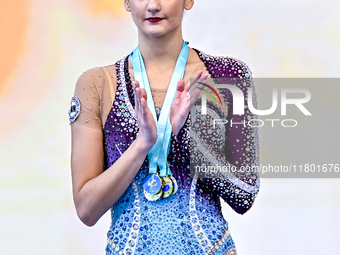 Gold medalist Alina Harnasko of Belarus celebrates on the podium after the Individual Clubs Final of the International Rhythmic Gymnastics T...