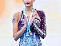 Gold medalist Alina Harnasko of Belarus celebrates on the podium after the Individual Clubs Final of the International Rhythmic Gymnastics T...