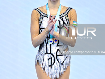 Bronze medalist Takhmina Ikromova of Uzbekistan celebrates on the podium after the Individual Ribbon Final of the International Rhythmic Gym...