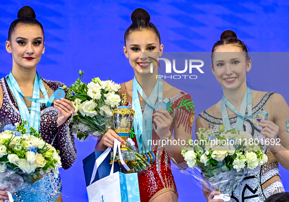 Gold medalist Mariia Borisova of Russia, silver medalist Alina Harnasko of Belarus, and bronze medalist Takhmina Ikromova of Uzbekistan stan...