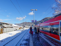 A red Deutsche Bahn train at Kochel am See Station in Bavaria, Germany, on November 22, 2024, contrasts with the pristine white snow coverin...