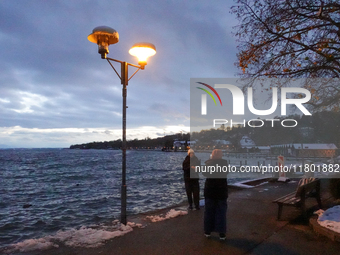 This waterfront promenade of Lake Starnberg in Germany, on November 22, 2024, is illuminated by a glowing streetlight that gently brightens...