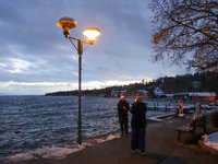 This waterfront promenade of Lake Starnberg in Germany, on November 22, 2024, is illuminated by a glowing streetlight that gently brightens...