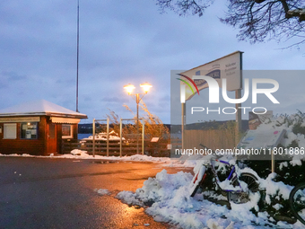 The Lake Starnberg waterfront promenade, adorned with fresh snow, creates a tranquil scene under the warm glow of streetlights in Lake Starn...