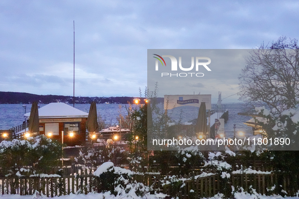 A view of the waterfront promenade at Lake Starnberg on November 22, 2024. Snow covers the ticket booth of the Bayerische Seenschifffahrt Gm...