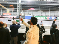 An Elvis impersonator takes a video of a Formula 1 car passing during the Formula 1 Heineken Silver Las Vegas Grand Prix in Las Vegas, Nevad...