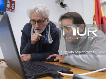 A technician helps Professor Angelo Torre, a professor of modern history at the University of Eastern Piedmont in Italy, prepare the compute...