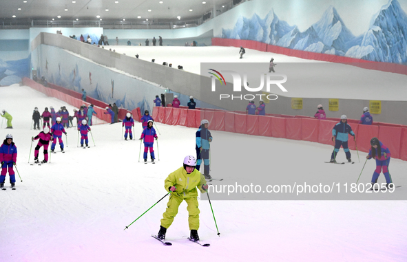 Tourists ski at the Kunlewan International Tourism Resort Ski Center in Handan, North China's Hebei province, on November 23, 2024. 