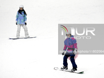 Tourists ski at the Kunlewan International Tourism Resort Ski Center in Handan, North China's Hebei province, on November 23, 2024. (