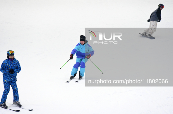 Tourists ski at the Kunlewan International Tourism Resort Ski Center in Handan, North China's Hebei province, on November 23, 2024. 