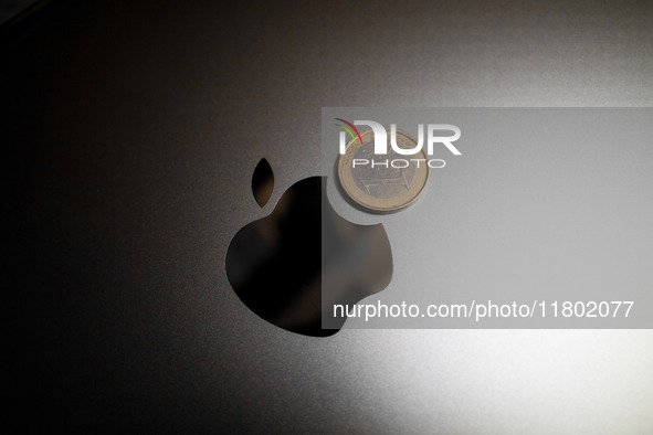 An Apple logo is on the back of a MacBook next to a one Euro coin in Athens, Greece, on November 23, 2024. 