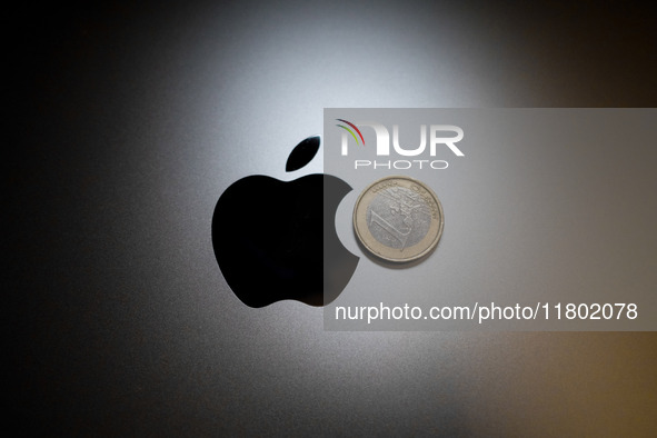 An Apple logo is on the back of a MacBook next to a one Euro coin in Athens, Greece, on November 23, 2024. 