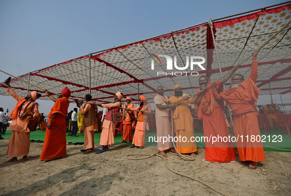 Sadhus (Hindu holy men) pull a rope during the Dharam Dhwaja (religious flag) ceremony at the Sangam area, ahead of the upcoming Maha Kumbh...