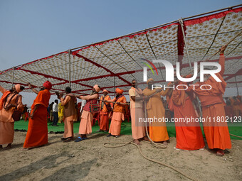 Sadhus (Hindu holy men) pull a rope during the Dharam Dhwaja (religious flag) ceremony at the Sangam area, ahead of the upcoming Maha Kumbh...