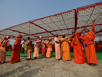 Sadhus (Hindu holy men) pull a rope during the Dharam Dhwaja (religious flag) ceremony at the Sangam area, ahead of the upcoming Maha Kumbh...