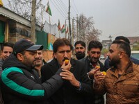 Bharatiya Janata Party (BJP) leaders and supporters distribute sweets as they celebrate after winning a majority in the Maharashtra state as...