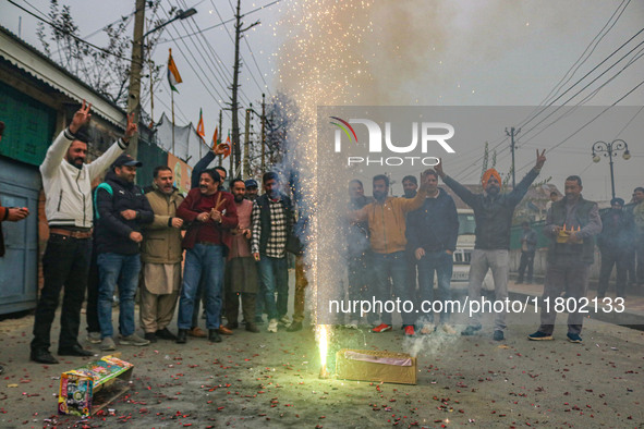 Bharatiya Janata Party (BJP) supporters shout slogans and light firecrackers as they celebrate after winning a majority in the Maharashtra s...