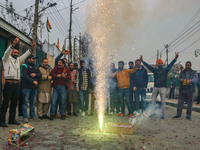 Bharatiya Janata Party (BJP) supporters shout slogans and light firecrackers as they celebrate after winning a majority in the Maharashtra s...