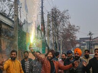 A Bharatiya Janata Party (BJP) supporter lights a firecracker as they celebrate after winning a majority in the Maharashtra state assembly e...