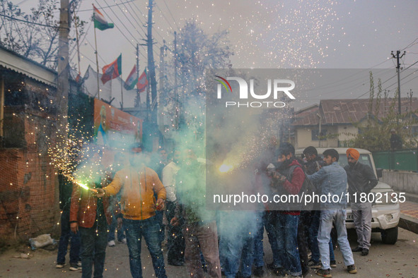 Bharatiya Janata Party (BJP) supporters shout slogans and light firecrackers as they celebrate after winning a majority in the Maharashtra s...