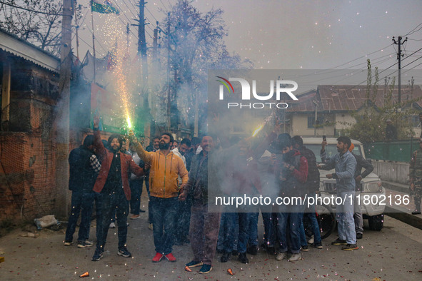 Bharatiya Janata Party (BJP) supporters shout slogans and light firecrackers as they celebrate after winning a majority in the Maharashtra s...