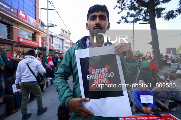 Nepali activists hold banners and placards with slogans demanding an end to Israel's aggression on Palestine during a demonstration in Kathm...