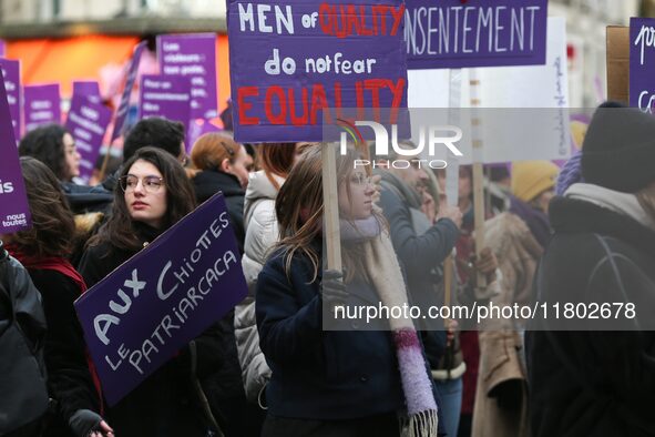 A woman holds a banner reading ''Men of quality do not fear equality'' as she participates in a protest to condemn violence against women, o...