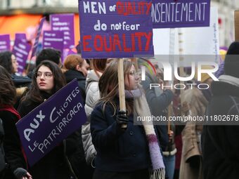 A woman holds a banner reading ''Men of quality do not fear equality'' as she participates in a protest to condemn violence against women, o...