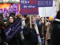 A woman holds a banner reading ''Men of quality do not fear equality'' as she participates in a protest to condemn violence against women, o...