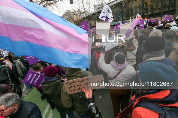 Demonstrators hold placards and a transgender flag as they participate in a protest to condemn violence against women, called by feminist or...