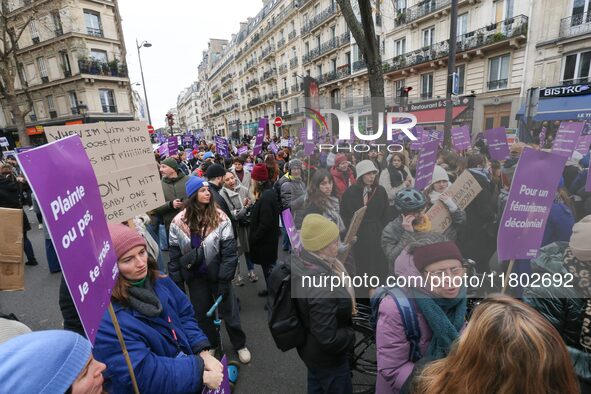 Demonstrators hold placards as they participate in a protest to condemn violence against women, organized by feminist organizations, in Pari...