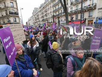 Demonstrators hold placards as they participate in a protest to condemn violence against women, organized by feminist organizations, in Pari...