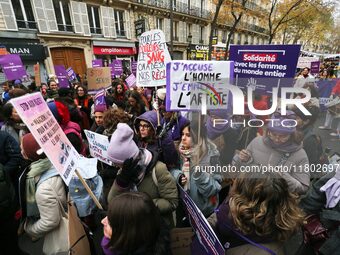 Demonstrators hold placards as they participate in a protest to condemn violence against women, organized by feminist organizations, in Pari...