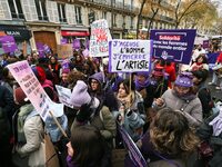 Demonstrators hold placards as they participate in a protest to condemn violence against women, organized by feminist organizations, in Pari...