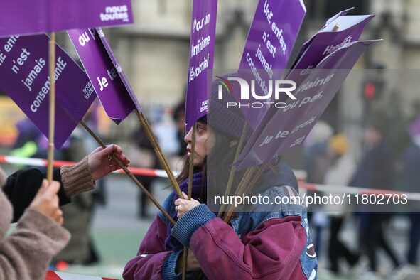 A woman distributes placards as she participates in a protest to condemn violence against women, organized by feminist organizations two day...