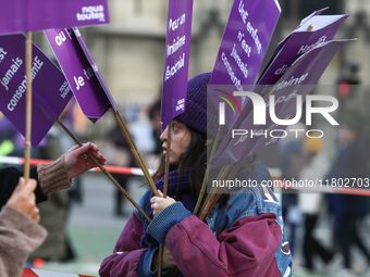 A woman distributes placards as she participates in a protest to condemn violence against women, organized by feminist organizations two day...