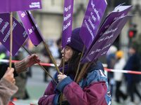 A woman distributes placards as she participates in a protest to condemn violence against women, organized by feminist organizations two day...